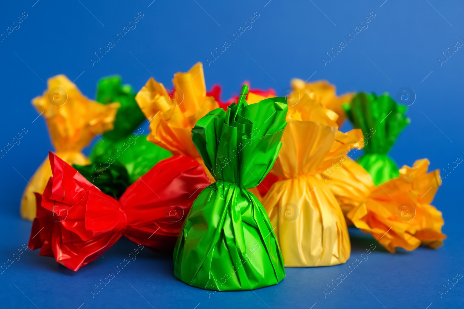 Photo of Candies in colorful wrappers on blue background