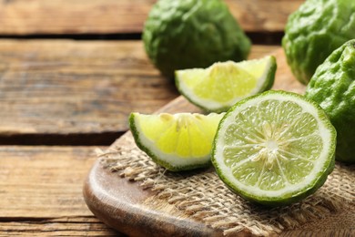 Fresh ripe bergamot fruits on wooden table, space for text