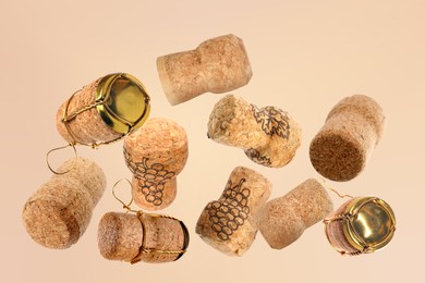 Image of Many corks of sparkling wine bottles falling on beige background