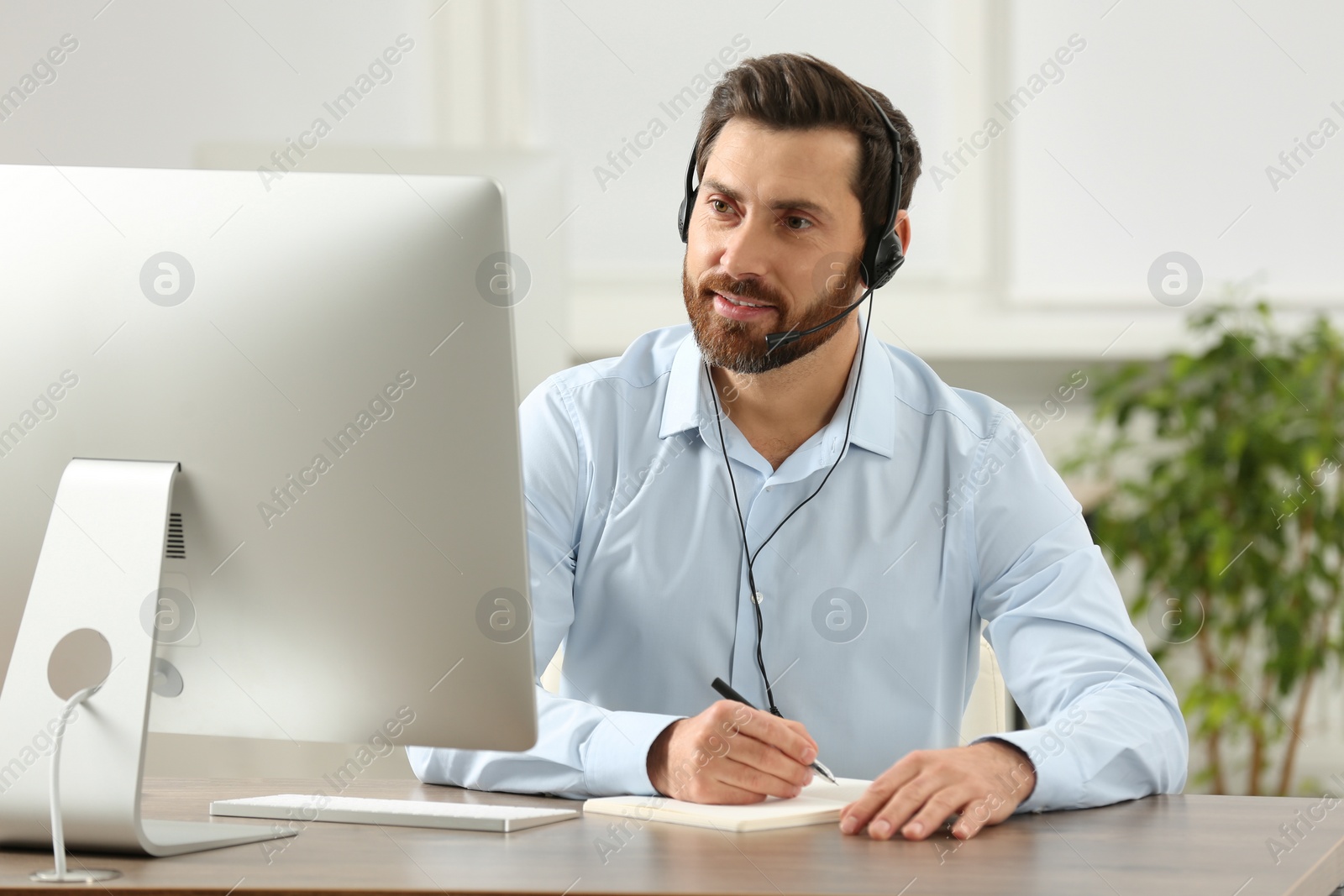 Photo of Hotline operator with headset working in office