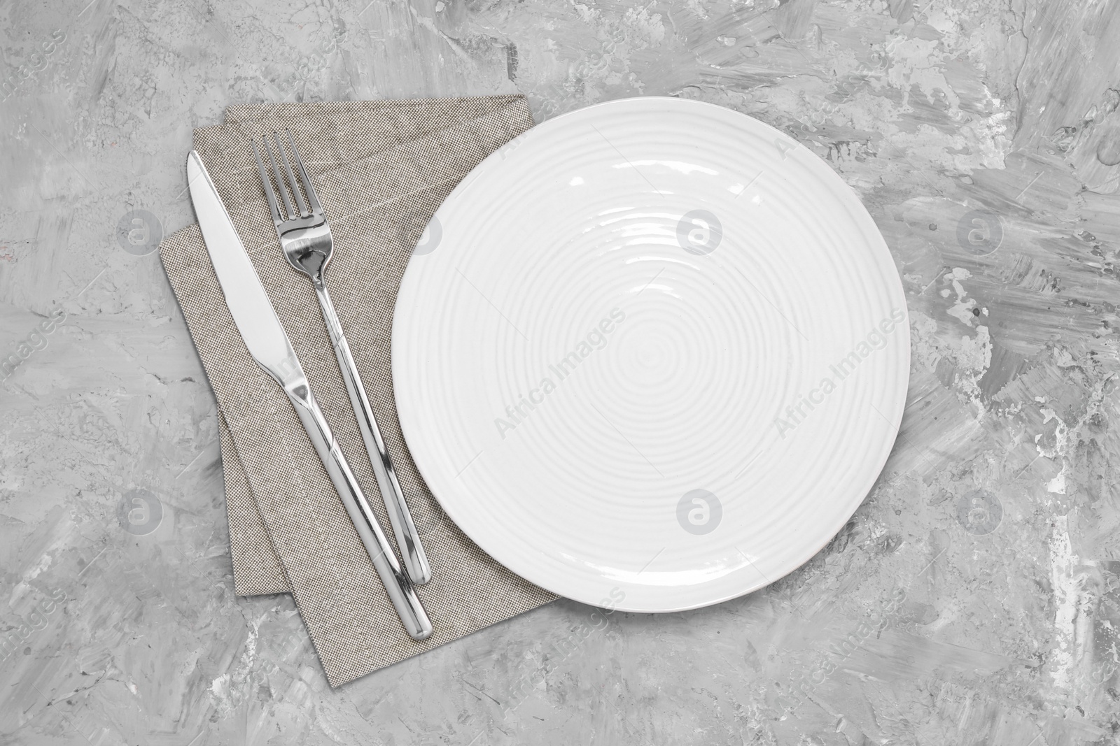 Photo of Elegant setting with shiny cutlery on grey table, top view