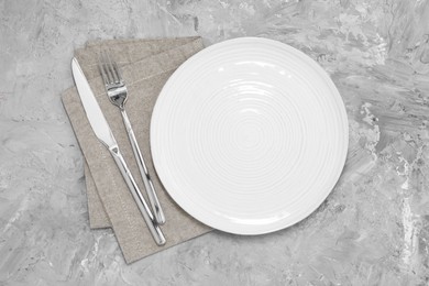 Elegant setting with shiny cutlery on grey table, top view