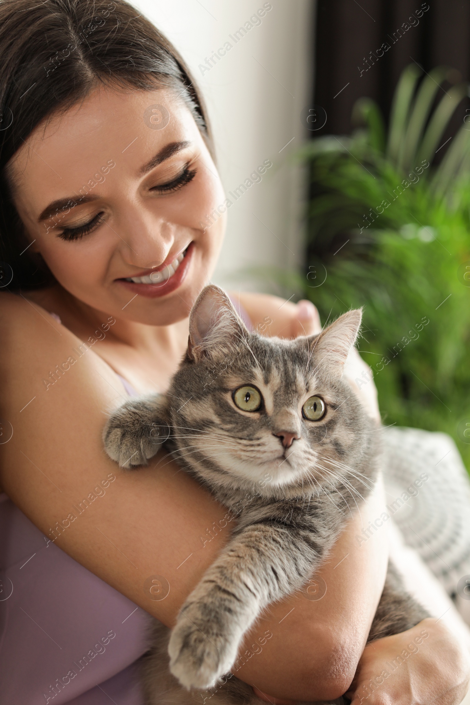 Photo of Young woman with cute cat at home. Pet and owner