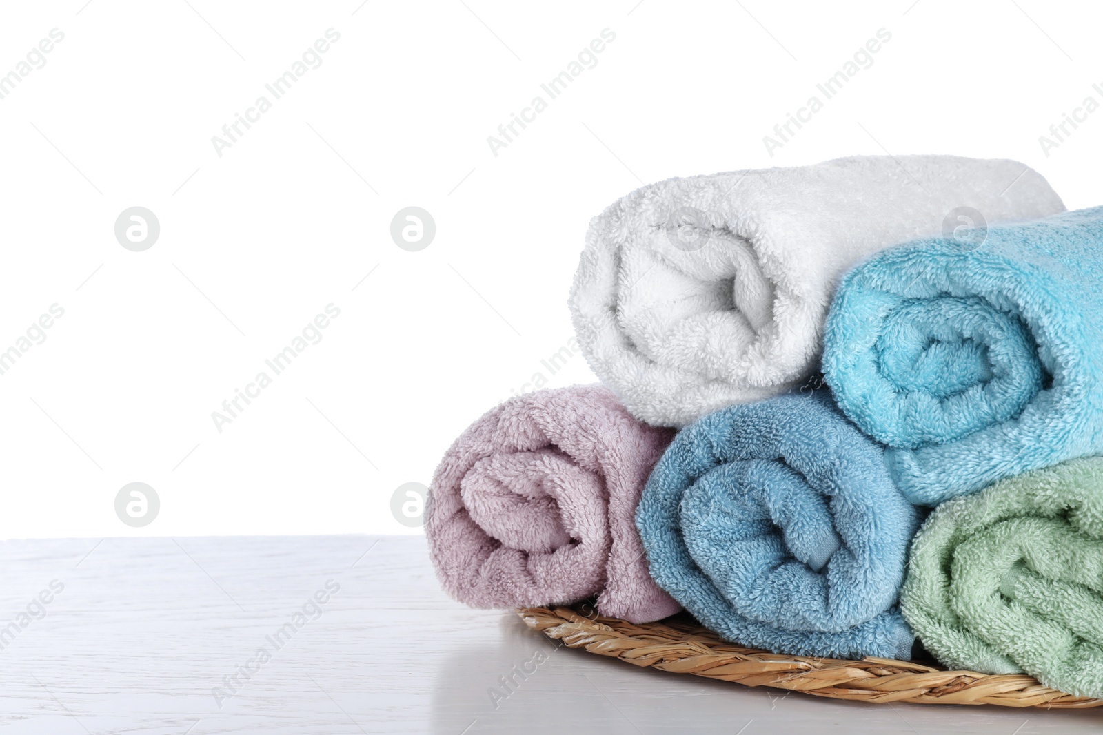 Photo of Fresh towels on wooden table against white background. Space for text