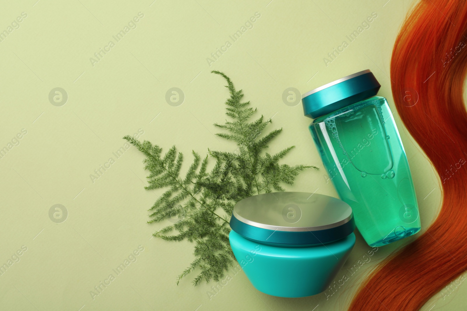 Photo of Natural cosmetic products, leaves and hair lock on light green background, flat lay. Space for text