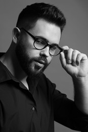 Portrait of handsome bearded man on grey background. Black and white effect