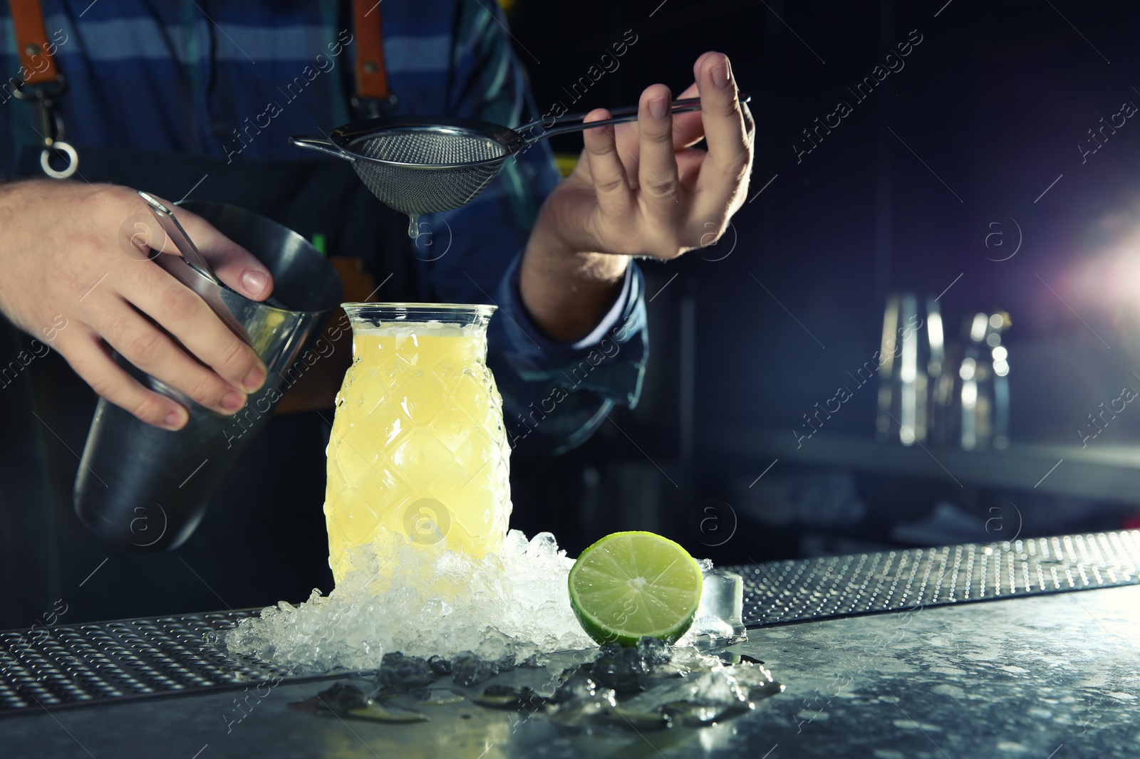 Photo of Barman making tropical cocktail at counter in pub, closeup. Space for text