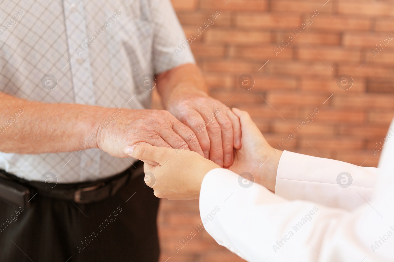 Photo of Helping hands on blurred background, closeup. Elderly care concept