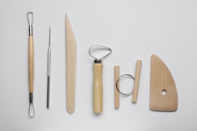 Photo of Set of clay modeling tools on white background, flat lay