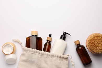 Photo of Preparation for spa. Compact toiletry bag and cosmetic products on white background, flat lay. Space for text