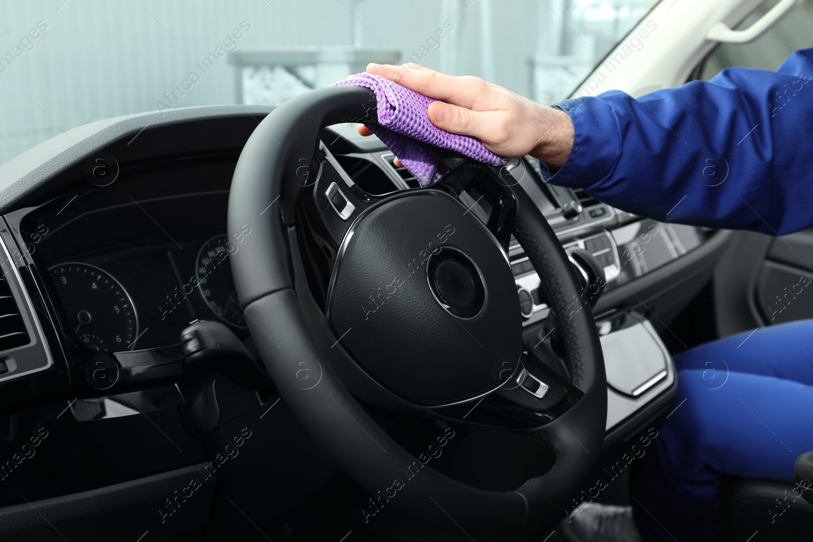 Photo of Car wash worker cleaning automobile interior, closeup