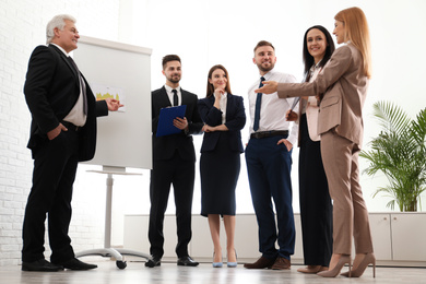 Photo of Senior business trainer working with people in office