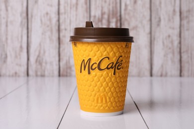 Photo of MYKOLAIV, UKRAINE - AUGUST 12, 2021: Hot McDonald's drink on white wooden table