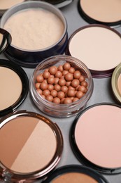 Photo of Different face powders on grey background, closeup