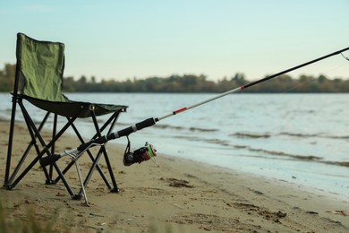 Photo of Folding chair and fishing rod at riverside