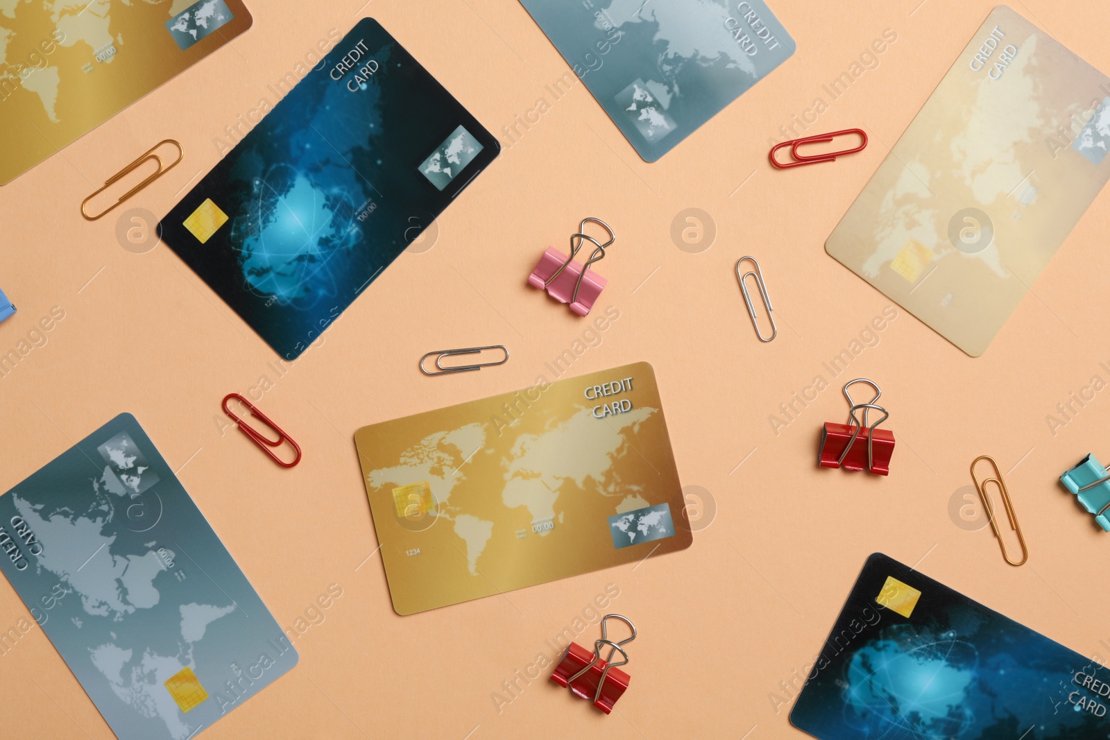 Photo of Flat lay composition with different credit cards and paper clips on beige background