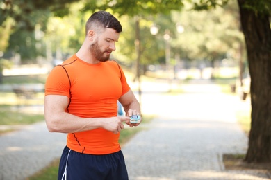 Young man checking pulse after workout in park