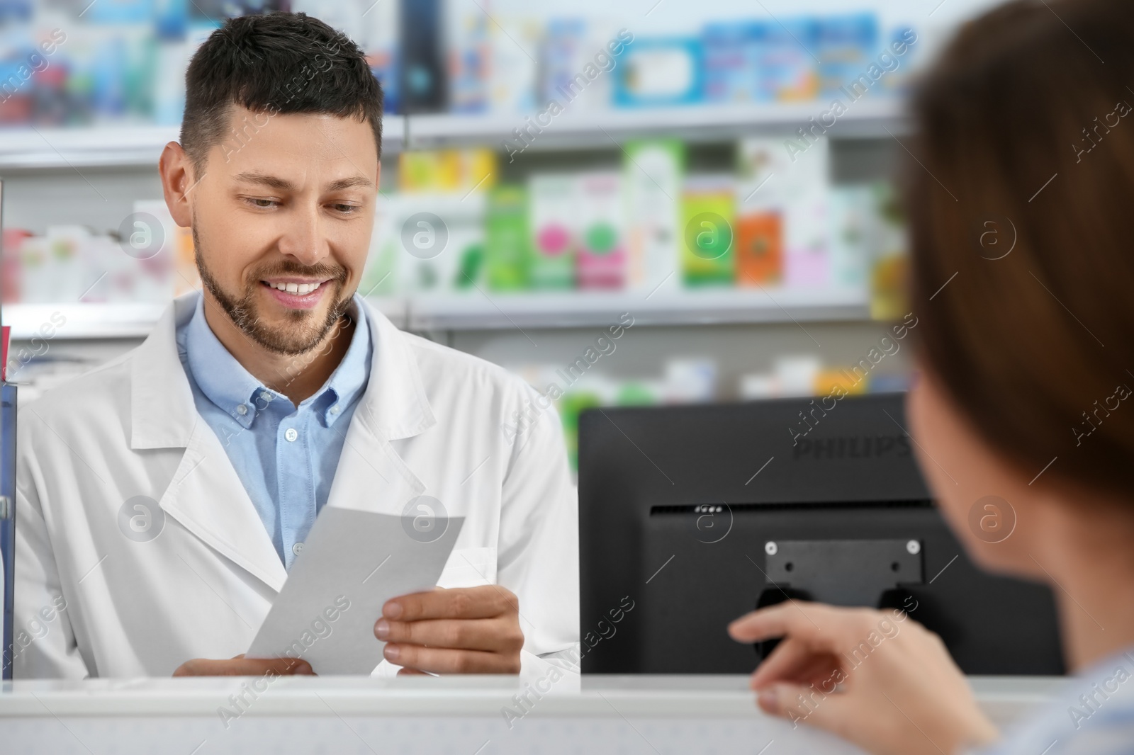 Photo of Professional pharmacist working with customer in drugstore