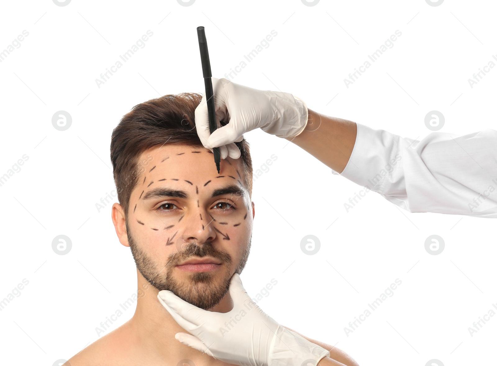 Photo of Doctor drawing marks on man's face for cosmetic surgery operation against white background