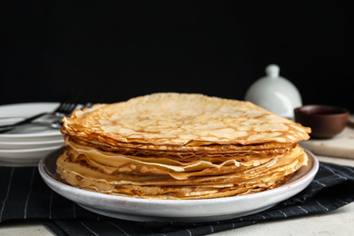 Stack of fresh thin pancakes on table