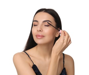 Photo of Young woman applying mascara on white background