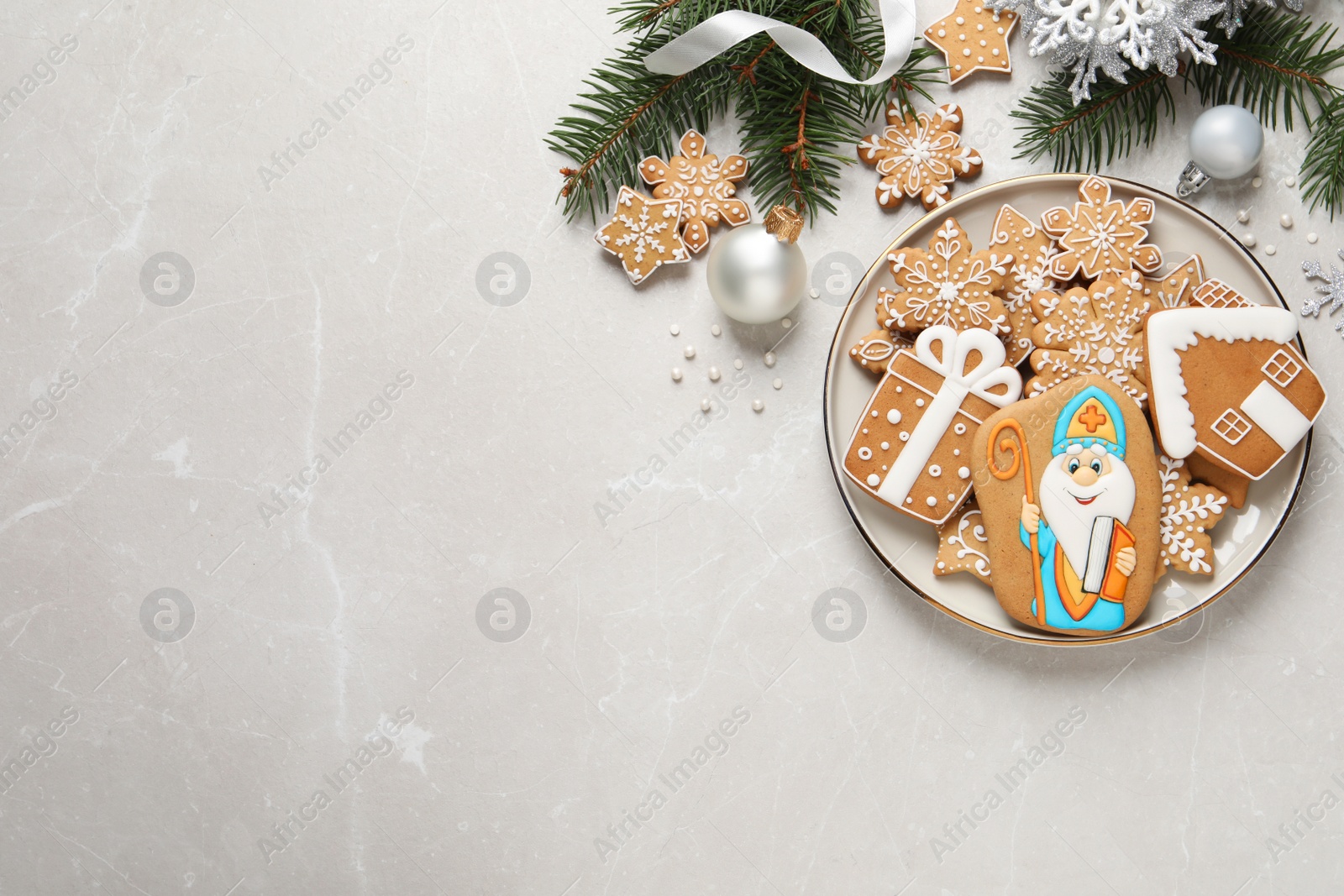 Photo of Tasty gingerbread cookies and festive decor on light table, flat lay with space for text. St. Nicholas Day celebration