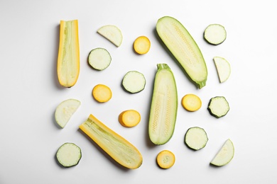 Photo of Fresh ripe cut zucchinis on white background, top view