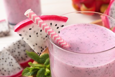 Photo of Glass of delicious pitahaya smoothie with fresh fruit, closeup