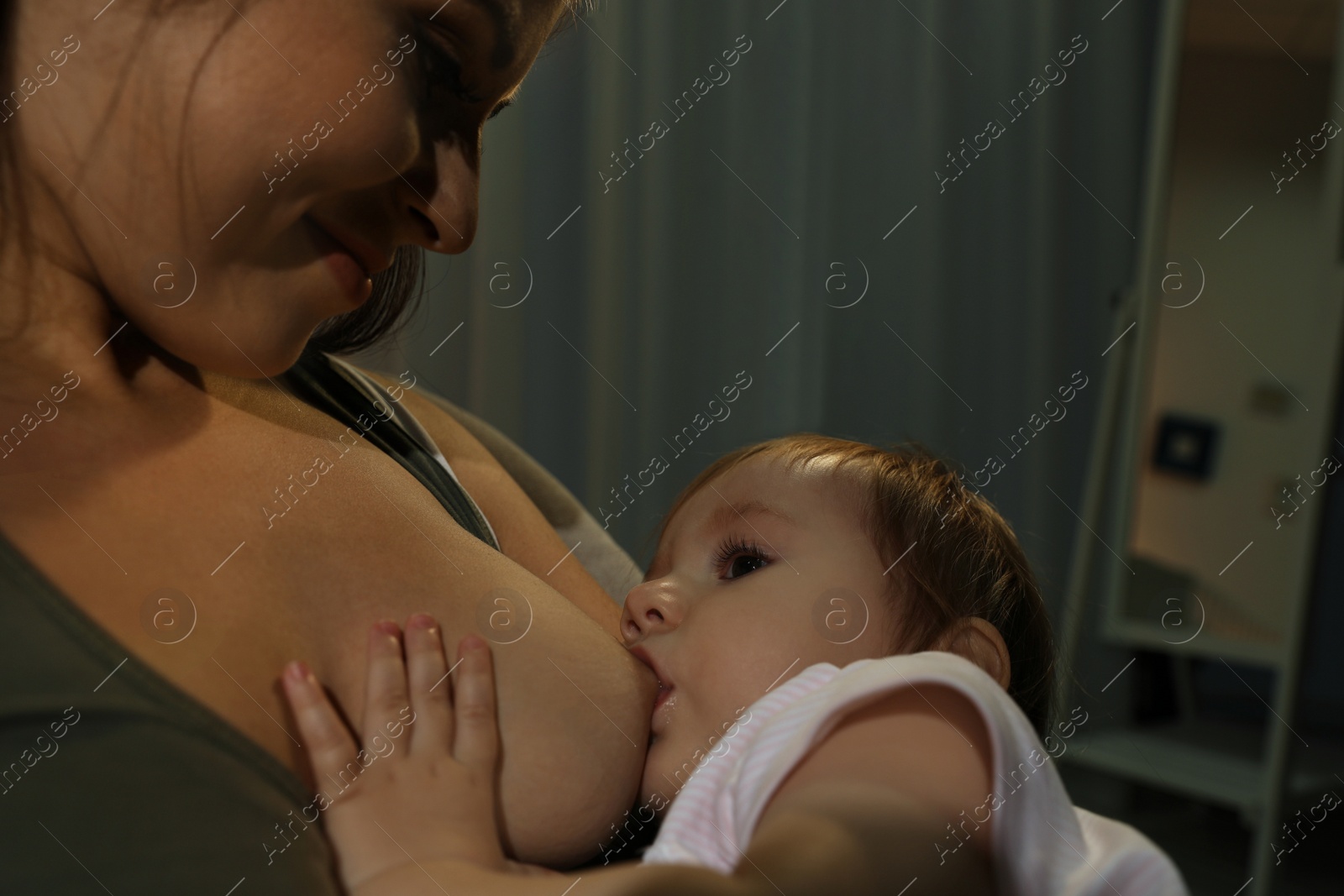 Photo of Woman breastfeeding her little baby at home