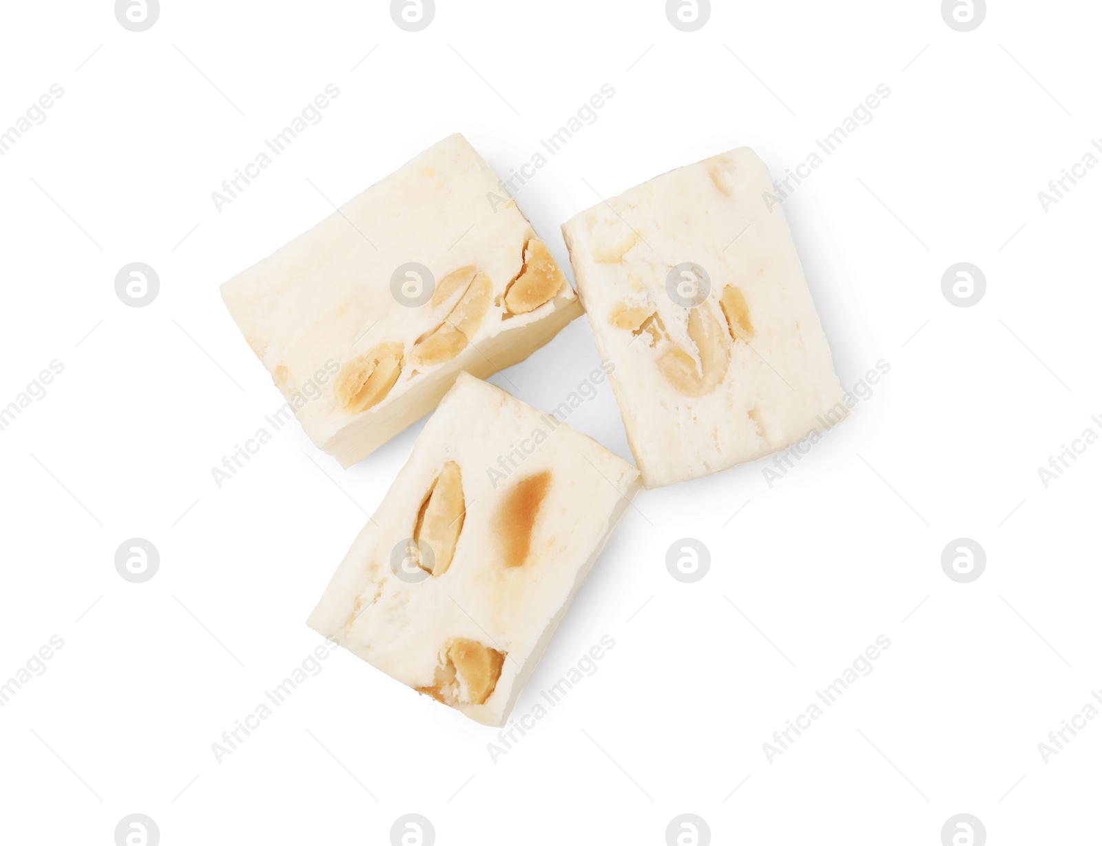 Photo of Pieces of delicious nougat on white background, top view