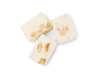 Photo of Pieces of delicious nougat on white background, top view