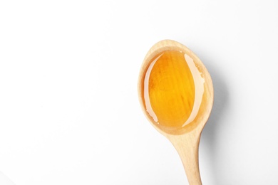 Spoon with delicious honey on white background, top view