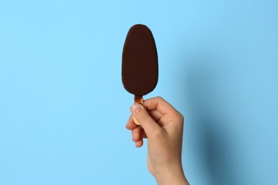 Photo of Woman holding delicious ice cream with chocolate against color background