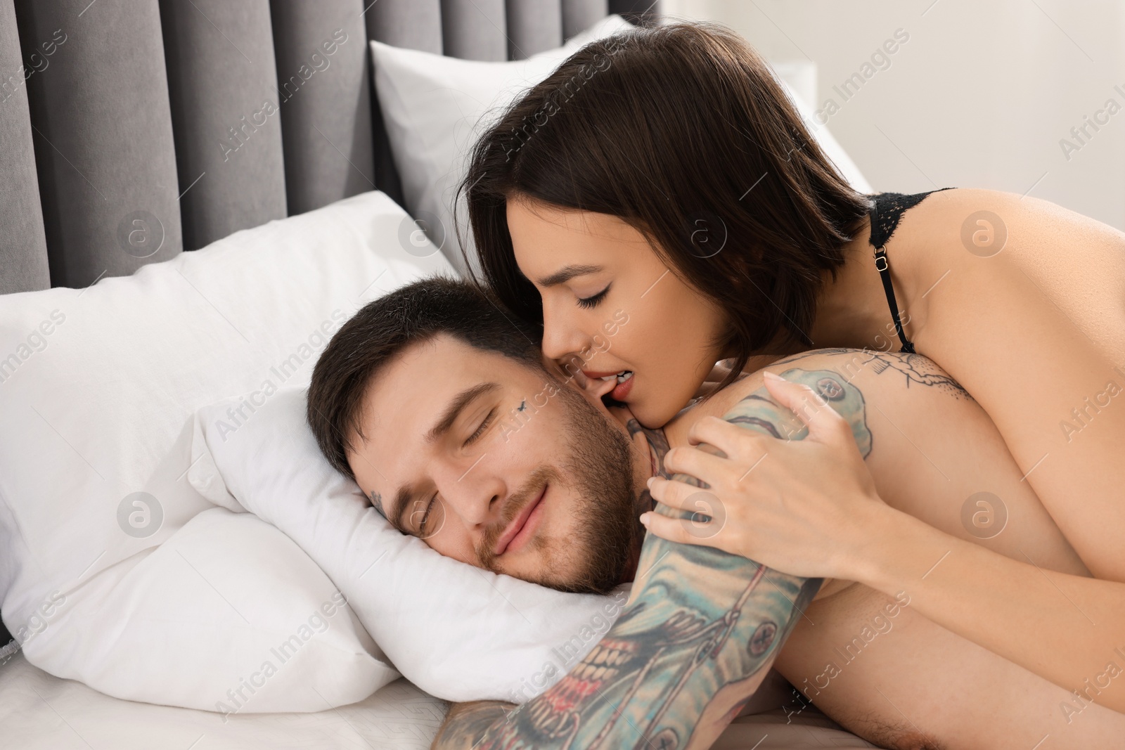 Photo of Passionate couple having sex on bed at home