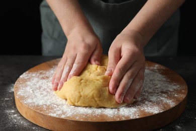 Photo of Making shortcrust pastry. Woman kneading dough at table, closeup