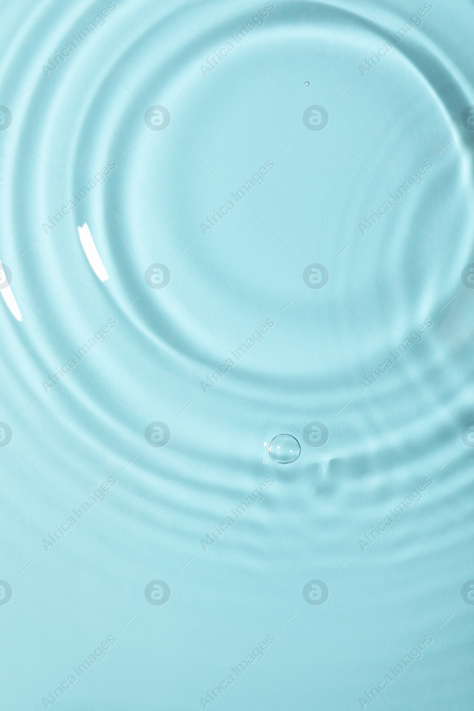 Photo of Closeup view of water with rippled surface on light blue background