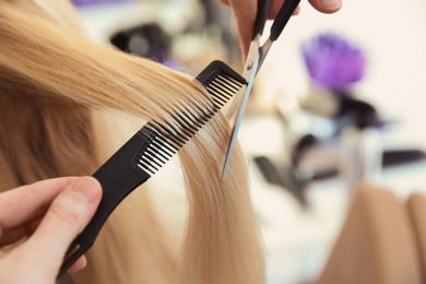 Photo of Professional hairdresser working with client in salon