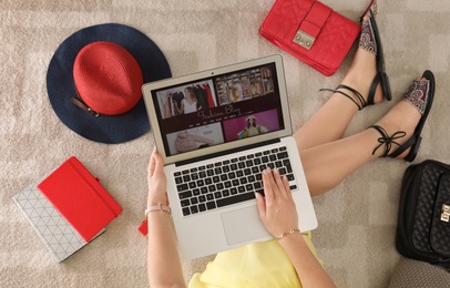 Woman and laptop with fashion blogger site on floor, top view