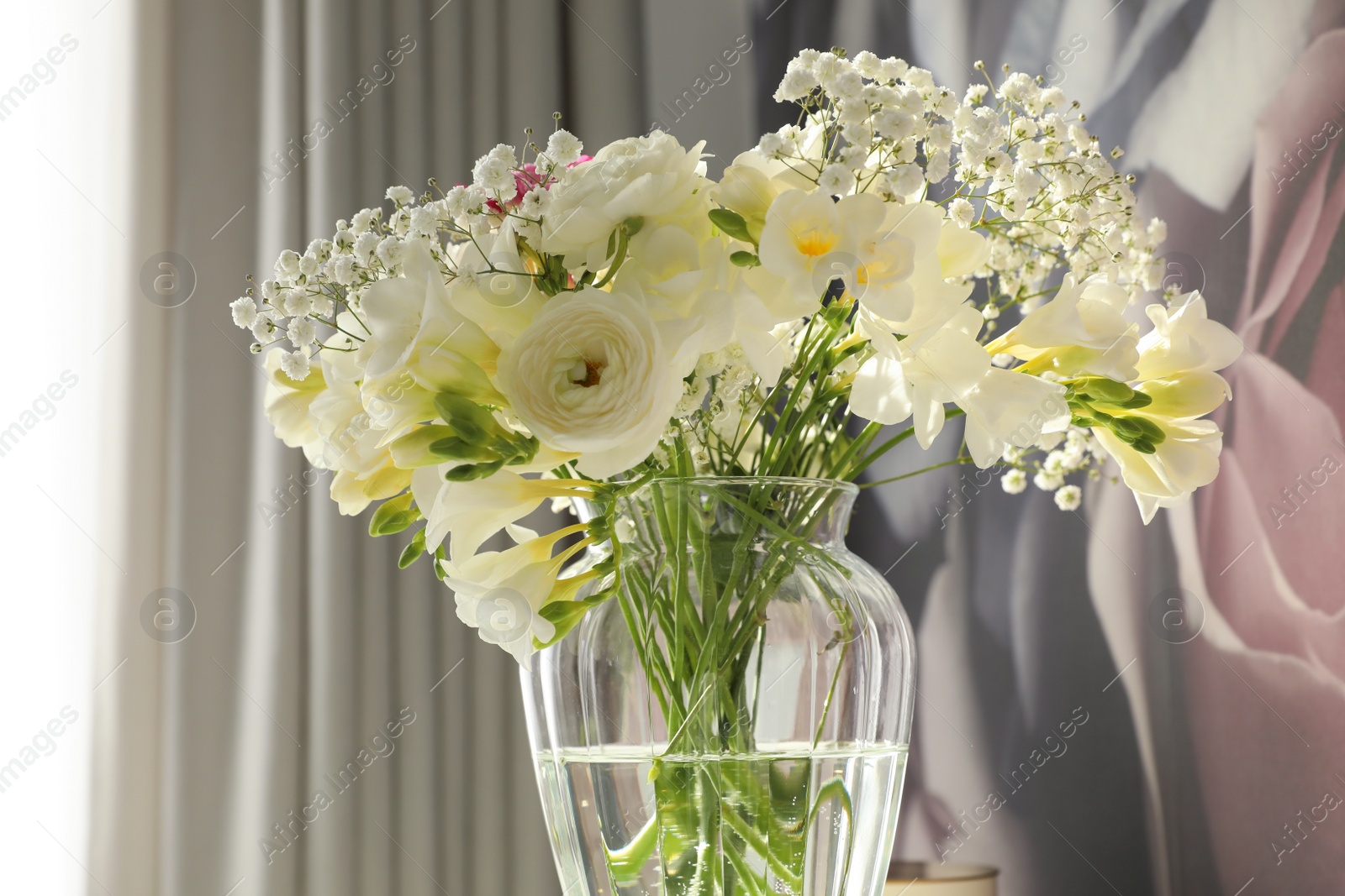 Photo of Beautiful bouquet with fresh freesia flowers in vase on color background, closeup