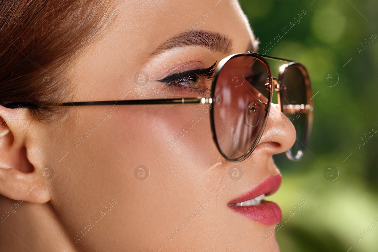 Photo of Beautiful woman in sunglasses outdoors on sunny day, closeup