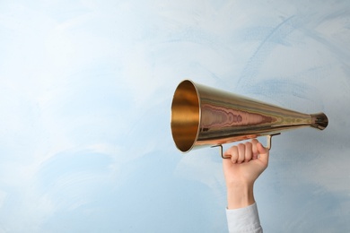 Woman holding retro megaphone on light background