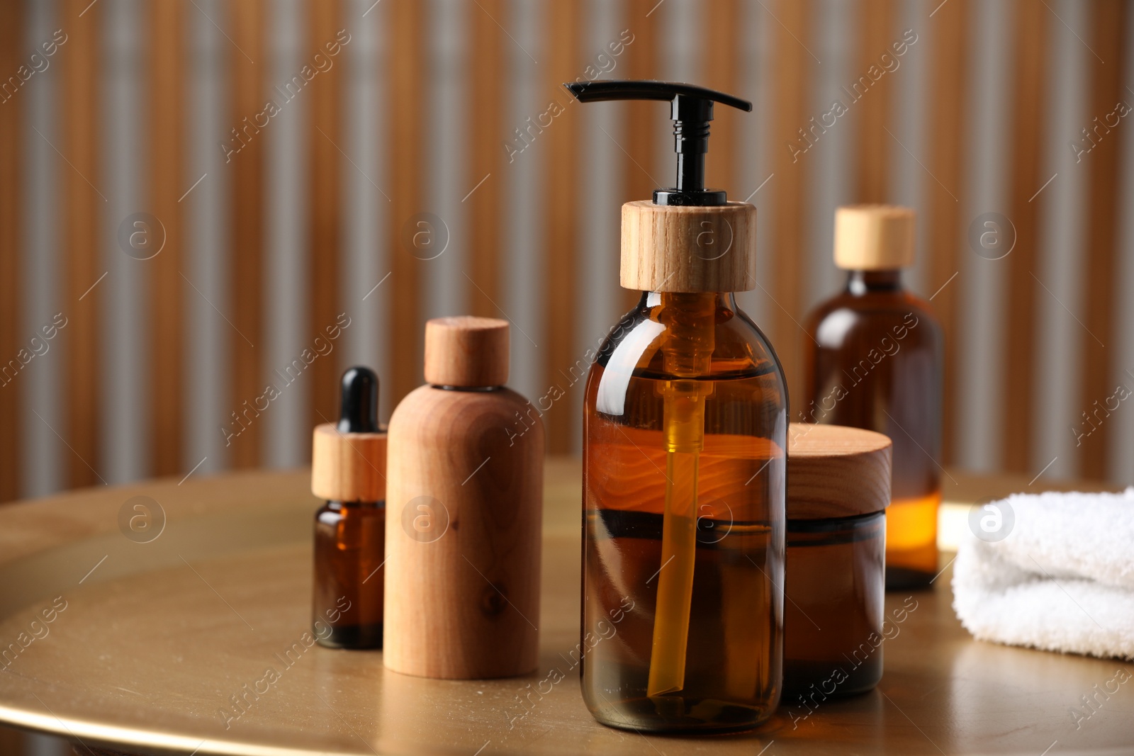 Photo of Bottle with dispenser cap and cosmetic products on tray indoors