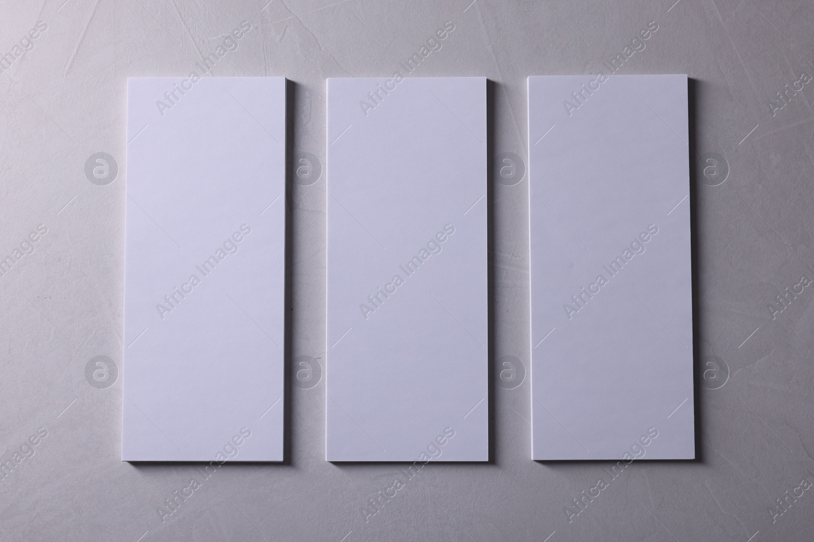 Photo of Blank business cards on light grey textured background, top view. Mockup for design