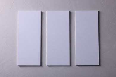 Photo of Blank business cards on light grey textured background, top view. Mockup for design