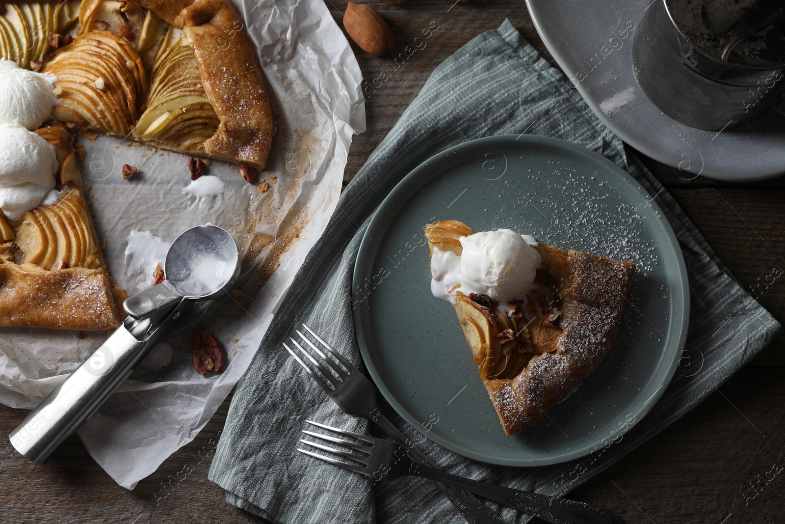 Photo of Delicious apple galette served with ice cream on wooden table, flat lay