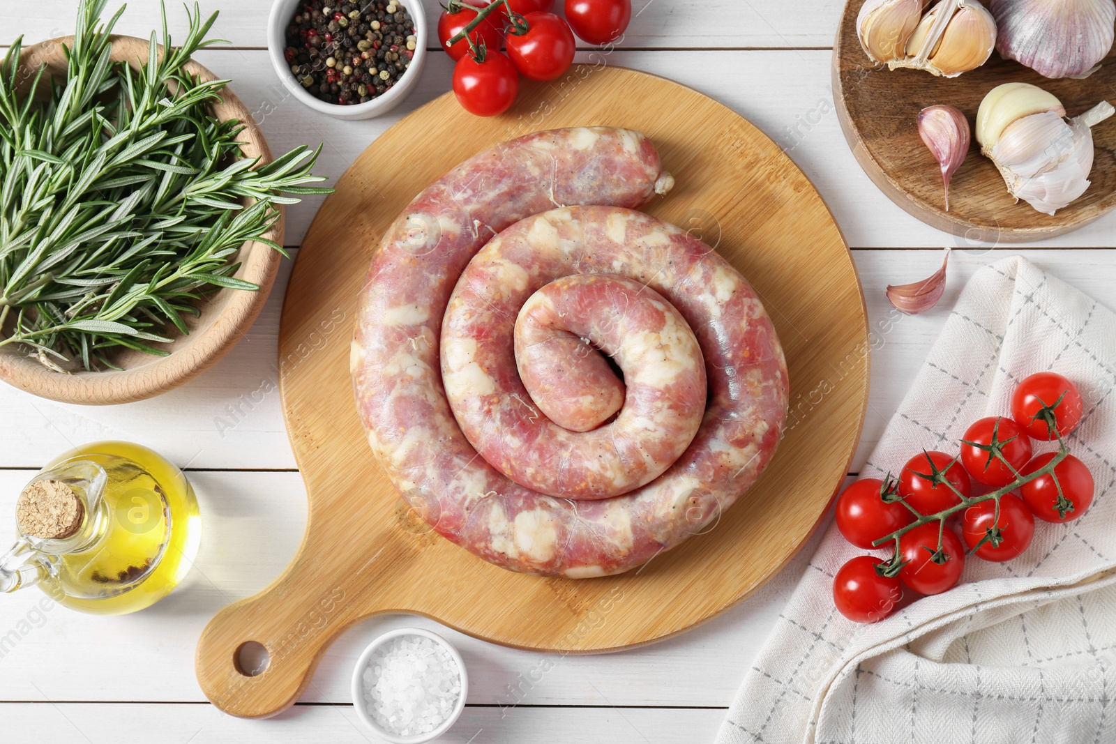 Photo of Raw homemade sausage, spices and other products on white wooden table, flat lay