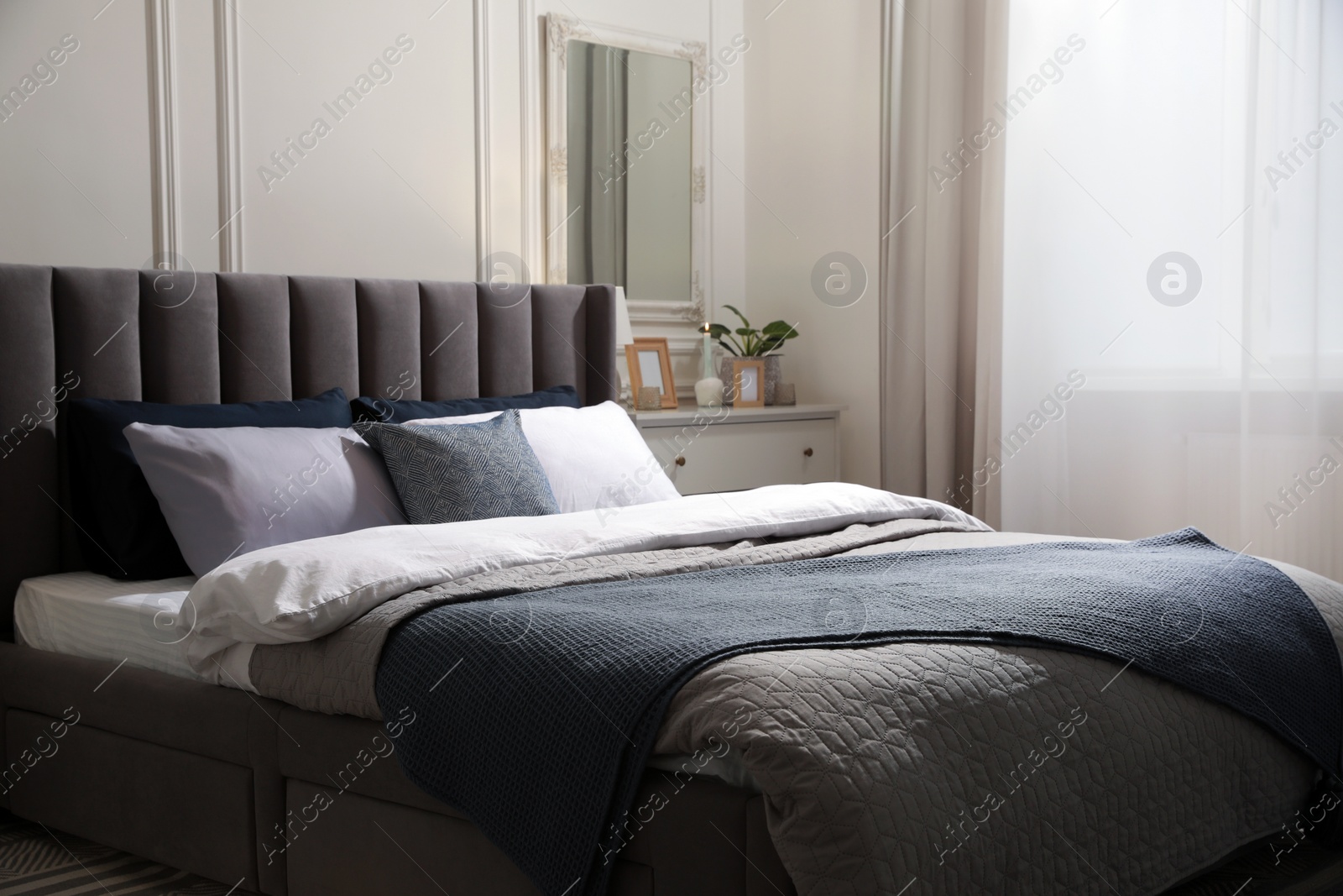 Photo of Comfortable bed with pillows and bedding in stylish room. Interior design