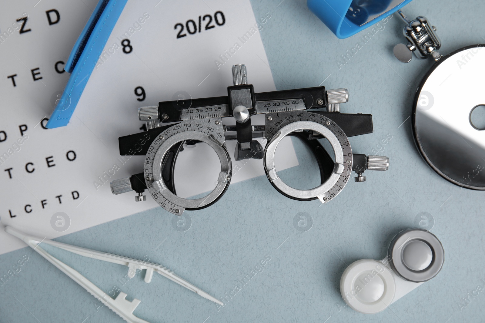 Photo of Different ophthalmologist tools on grey background, flat lay