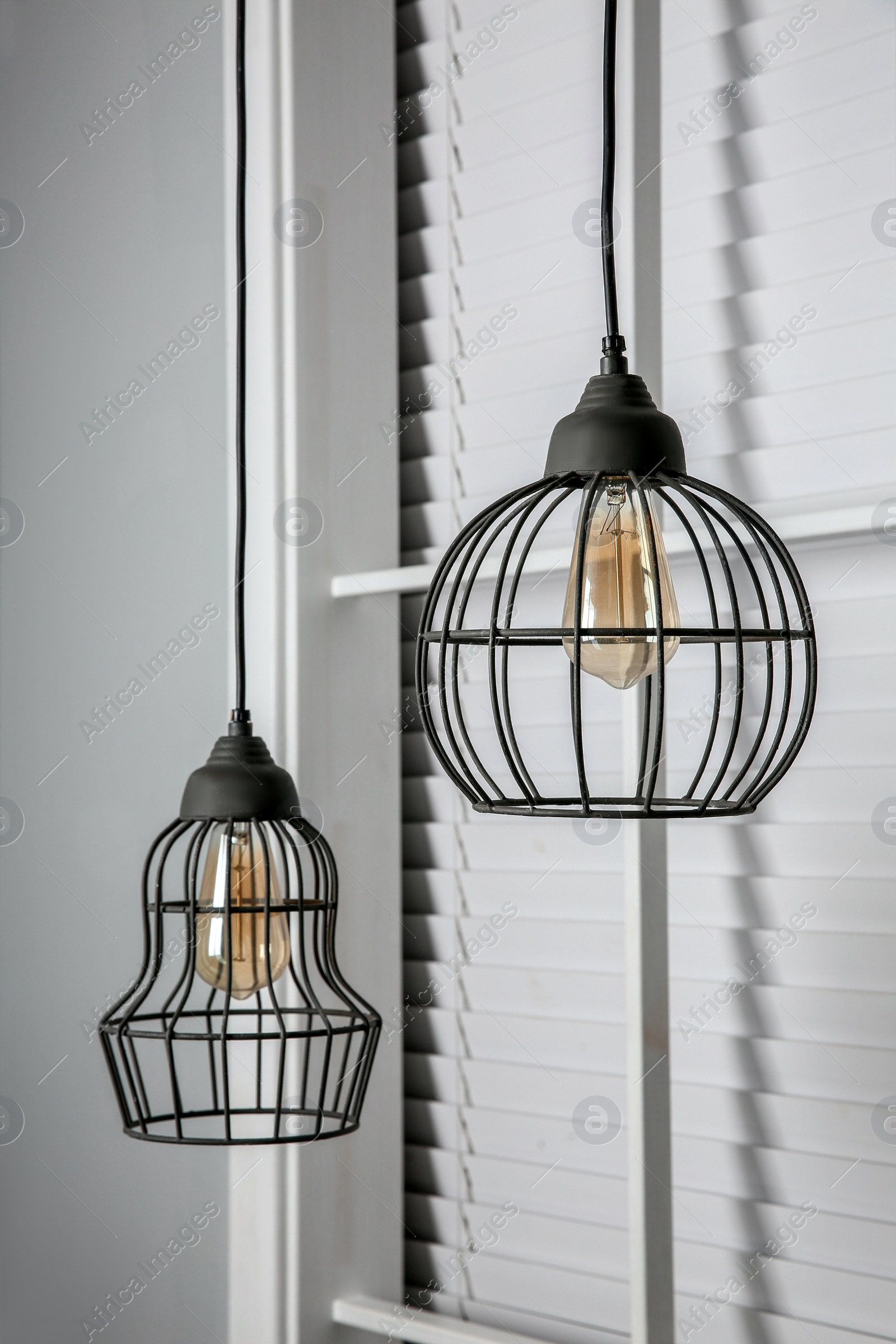 Photo of Stylish pendant lamps hanging near window indoors