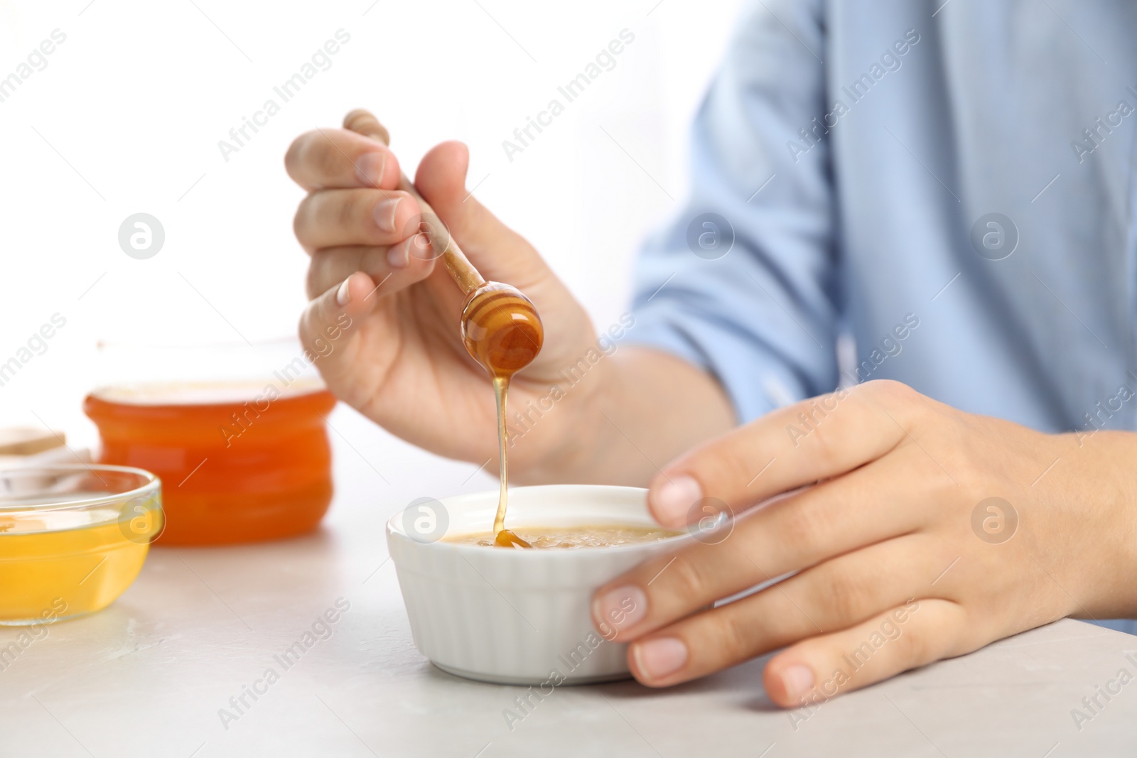 Photo of Woman preparing face mask at light table, closeup. Handmade cosmetic